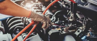 Autoelektrikář měří napětí ve vozidle pomocí multimetru